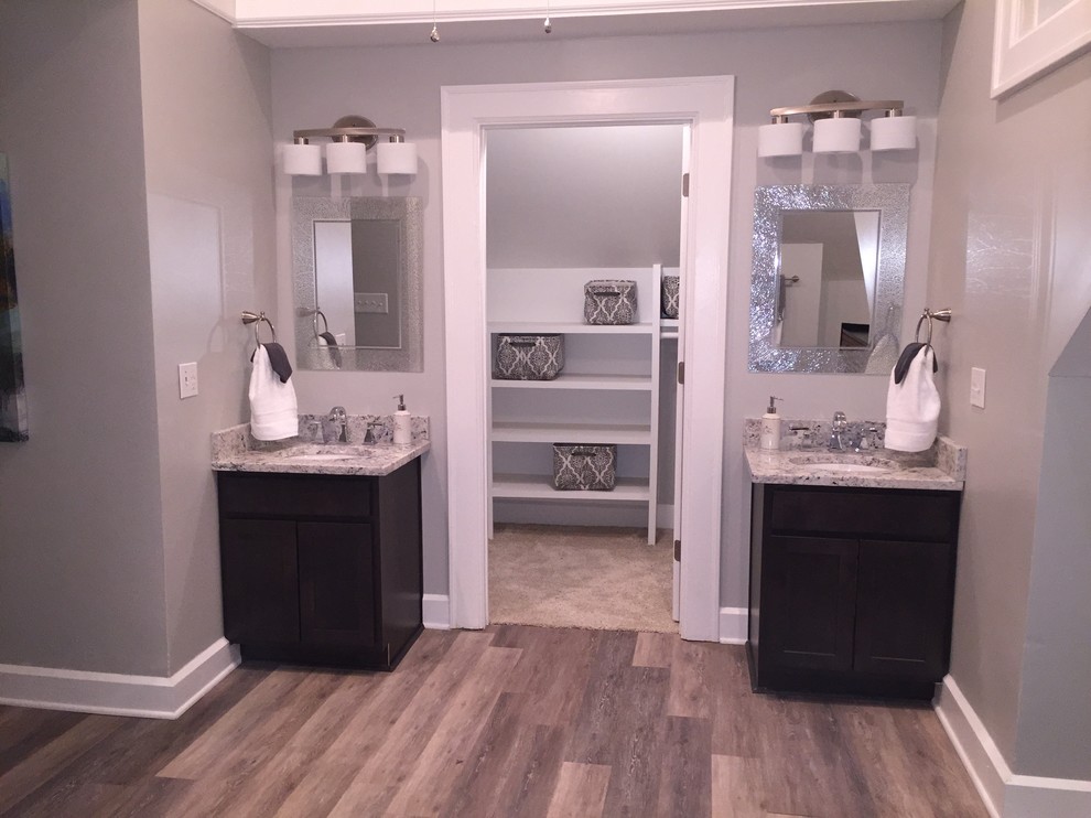 Immagine di una grande stanza da bagno padronale tradizionale con ante in stile shaker, ante in legno bruno, pareti grigie, pavimento in legno massello medio e lavabo sottopiano