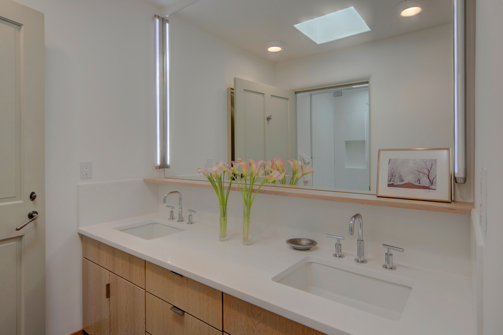 Стильный дизайн: ванная комната среднего размера в стиле фьюжн с плоскими фасадами, светлыми деревянными фасадами, белой плиткой, керамогранитной плиткой, белыми стенами, душевой кабиной, врезной раковиной, столешницей из искусственного кварца и белой столешницей - последний тренд
