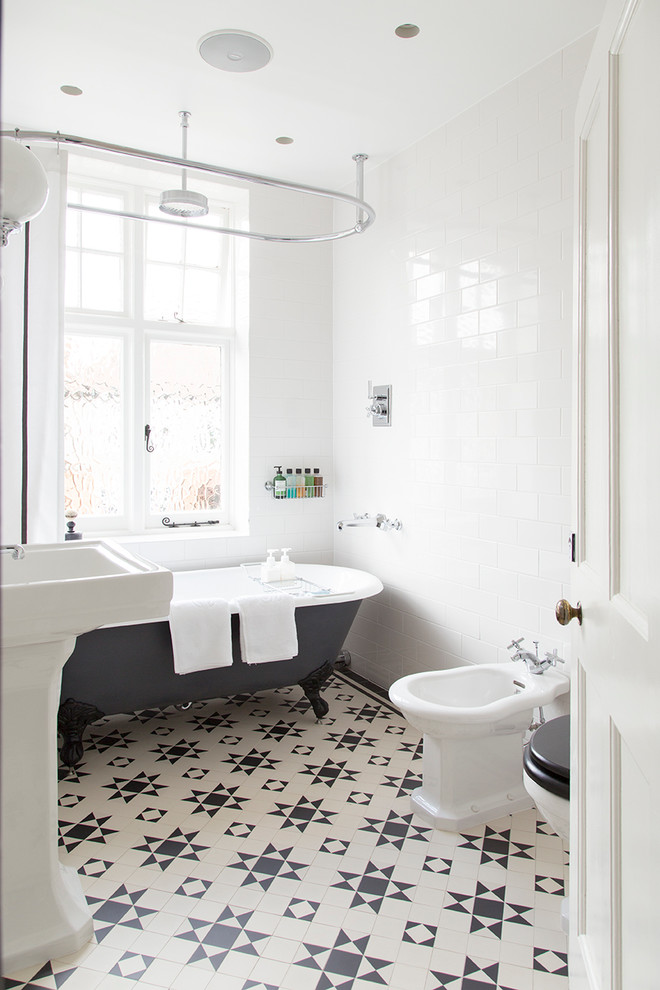 Свежая идея для дизайна: ванная комната среднего размера в классическом стиле с ванной на ножках, душем над ванной, биде, белой плиткой, плиткой кабанчик, белыми стенами, раковиной с пьедесталом и полом из керамической плитки - отличное фото интерьера