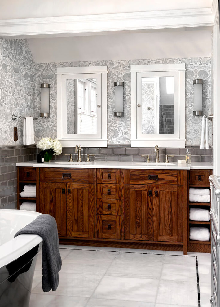 Inspiration pour une salle de bain principale traditionnelle en bois foncé de taille moyenne avec une baignoire indépendante, un carrelage gris, un carrelage métro, un mur gris, un sol en marbre, un plan de toilette en quartz, un sol blanc et un placard à porte shaker.