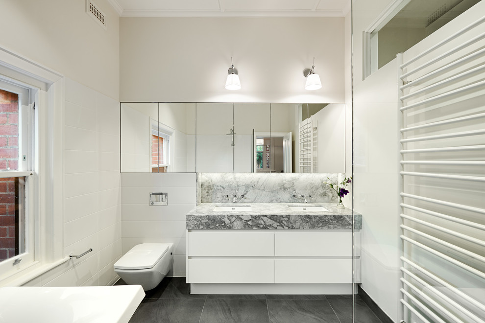 Immagine di una stanza da bagno minimal con vasca freestanding, pareti bianche, piastrelle in ceramica e pavimento con piastrelle in ceramica