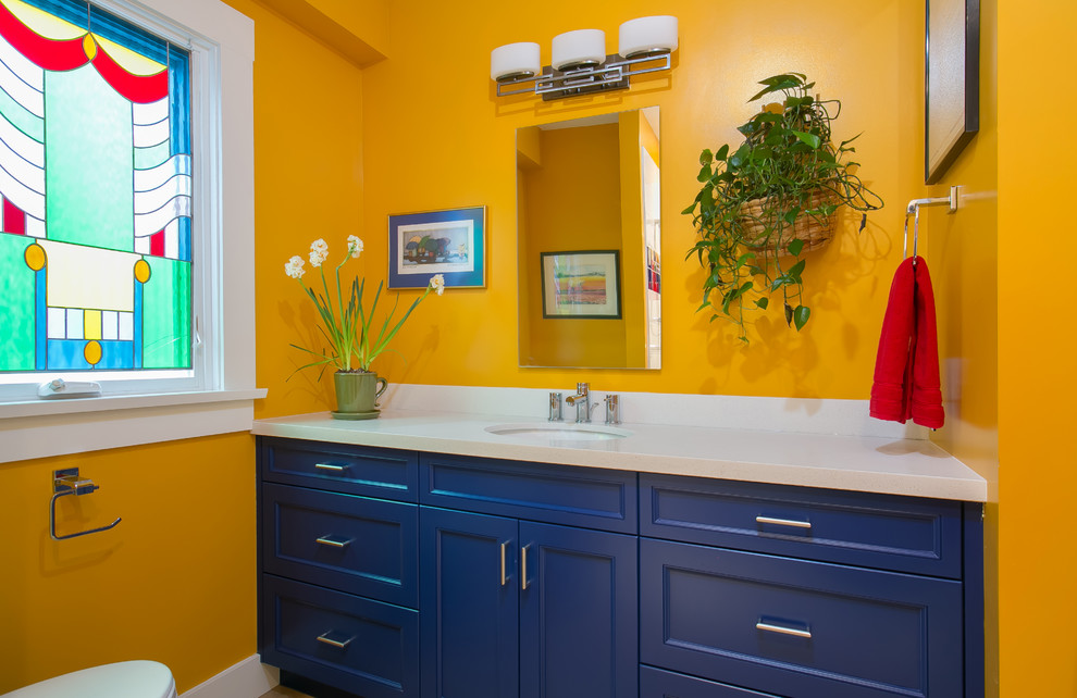 Immagine di una stanza da bagno tradizionale di medie dimensioni con lavabo sottopiano, ante con riquadro incassato, ante blu, doccia aperta, WC a due pezzi e pareti gialle