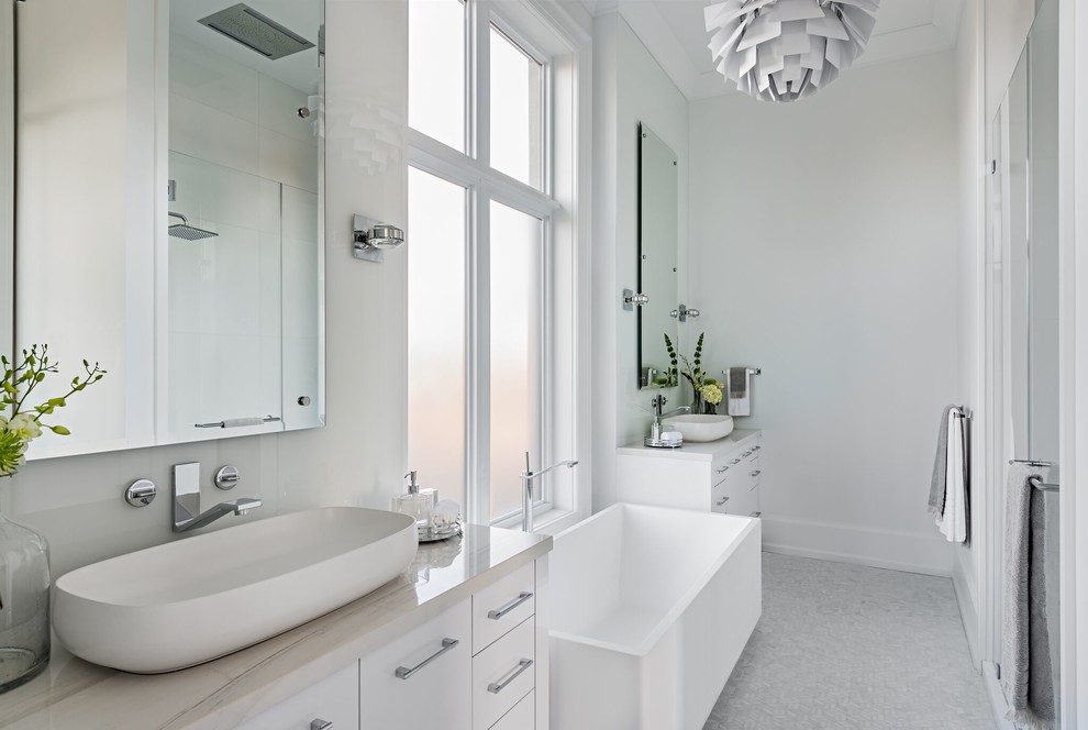 Exempel på ett modernt vit vitt en-suite badrum, med släta luckor, vita skåp, ett fristående badkar, vita väggar, ett fristående handfat och grått golv