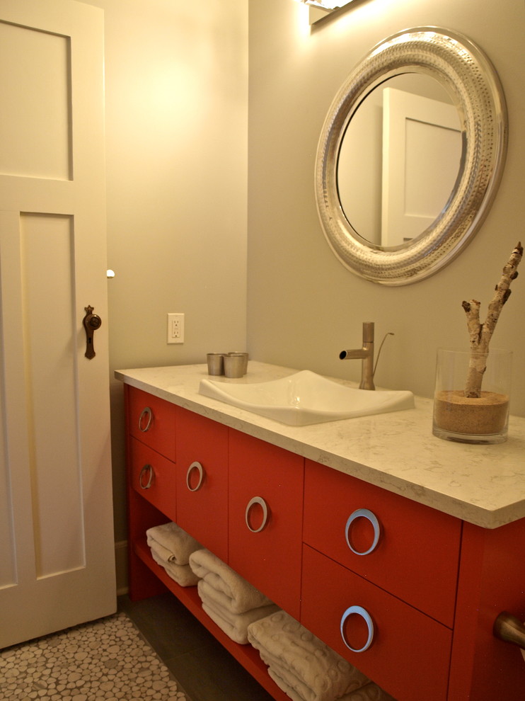 Mittelgroßes Modernes Badezimmer mit Aufsatzwaschbecken, flächenbündigen Schrankfronten, roten Schränken, Quarzwerkstein-Waschtisch, Wandtoilette mit Spülkasten, grauen Fliesen, Steinfliesen, grauer Wandfarbe und hellem Holzboden in Vancouver