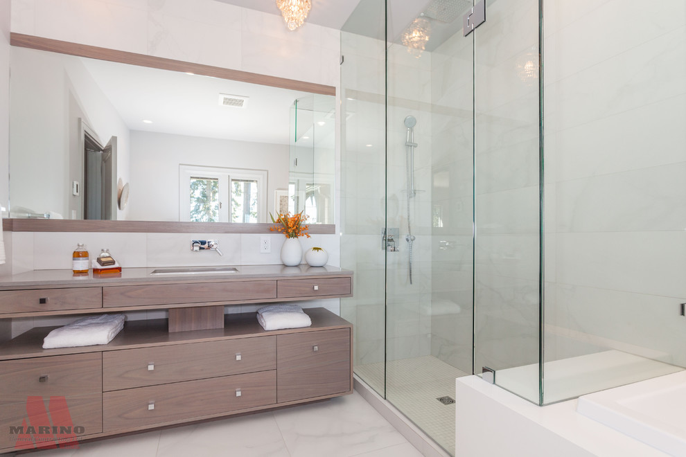 This is an example of a large contemporary ensuite bathroom in Vancouver with grey cabinets, a freestanding bath, a corner shower, a two-piece toilet, white tiles, stone tiles, white walls, marble flooring, a vessel sink and marble worktops.