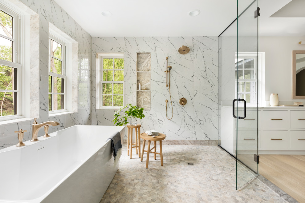 Design ideas for a coastal ensuite wet room bathroom in Minneapolis with flat-panel cabinets, white cabinets, a freestanding bath, white tiles, white walls, light hardwood flooring, beige floors, a hinged door, white worktops, a wall niche and a built in vanity unit.