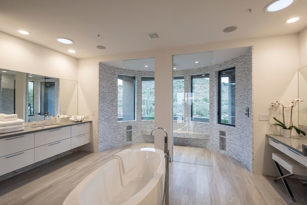 Bathroom - large contemporary master gray tile and stone tile laminate floor and beige floor bathroom idea in Phoenix with flat-panel cabinets, white cabinets, white walls and an undermount sink
