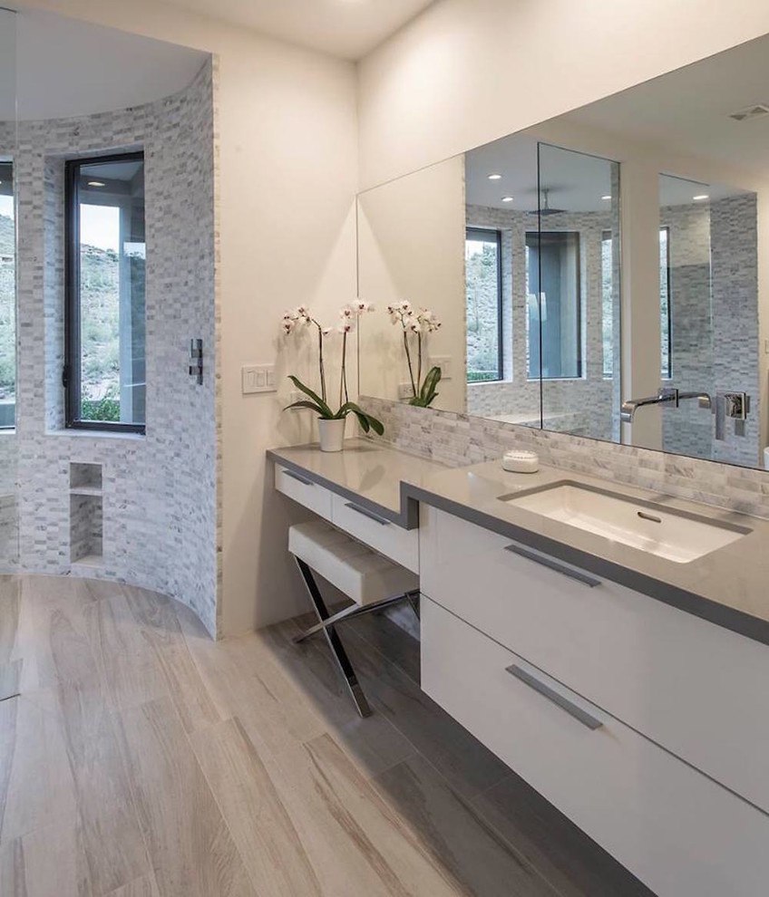 Exemple d'une grande salle de bain principale tendance avec un placard à porte plane, des portes de placard blanches, une baignoire indépendante, une douche double, un mur blanc, sol en stratifié, un lavabo encastré, un sol beige, aucune cabine, un carrelage gris et un carrelage de pierre.