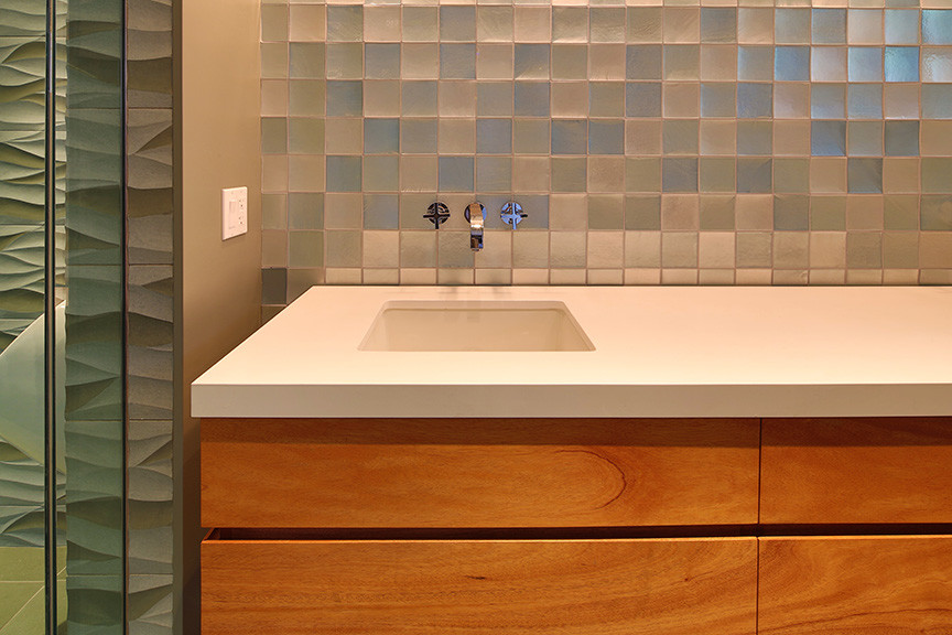 Doorless shower - large contemporary master blue tile and glass tile marble floor, gray floor and double-sink doorless shower idea in Los Angeles with flat-panel cabinets, medium tone wood cabinets, a wall-mount toilet, blue walls and quartzite countertops