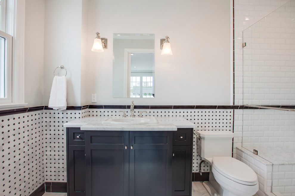 Inredning av ett klassiskt badrum, med skåp i shakerstil, svarta skåp, en toalettstol med hel cisternkåpa, svart och vit kakel, vita väggar och ett nedsänkt handfat