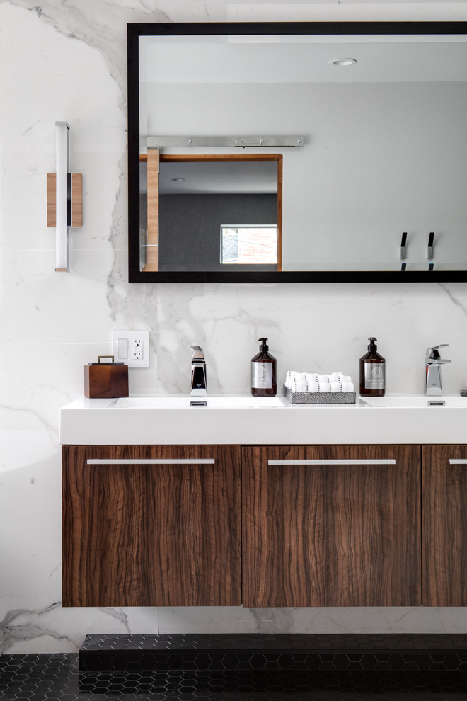 Inspiration for a medium sized modern ensuite bathroom in Orange County with flat-panel cabinets, medium wood cabinets, a freestanding bath, a corner shower, a two-piece toilet, white tiles, stone slabs, white walls, marble flooring, an integrated sink, engineered stone worktops, white floors, a hinged door and white worktops.