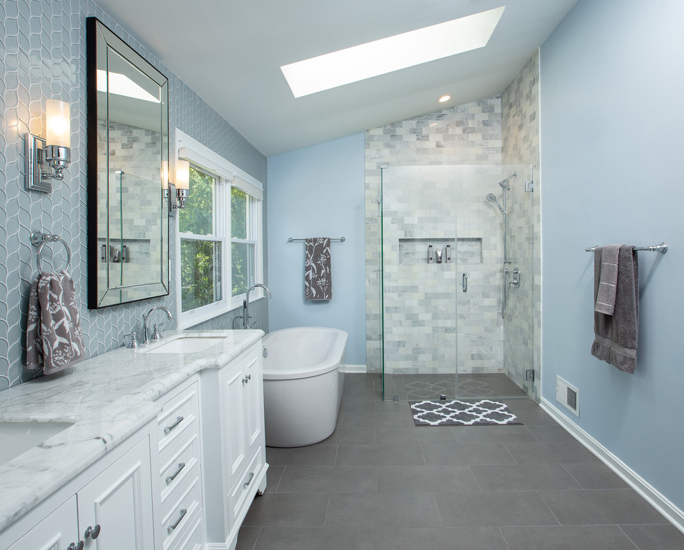Идея дизайна: главная ванная комната в стиле неоклассика (современная классика) с белыми фасадами, отдельно стоящей ванной, угловым душем, серой плиткой, синими стенами, врезной раковиной, серым полом, душем с распашными дверями, серой столешницей и фасадами с утопленной филенкой