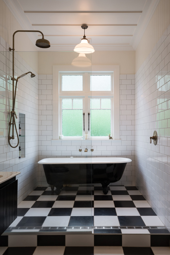 Пример оригинального дизайна: главная ванная комната в классическом стиле с черными фасадами, ванной на ножках, душевой комнатой, желтыми стенами и открытым душем