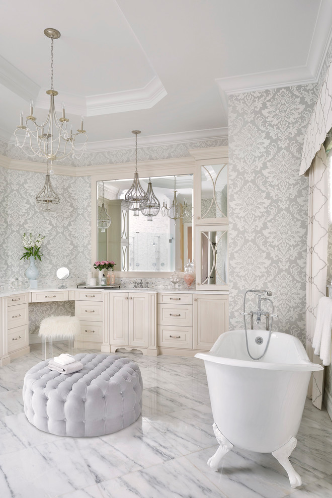 Immagine di una stanza da bagno classica con ante con bugna sagomata, ante beige, vasca con piedi a zampa di leone, pareti grigie, pavimento grigio e top bianco