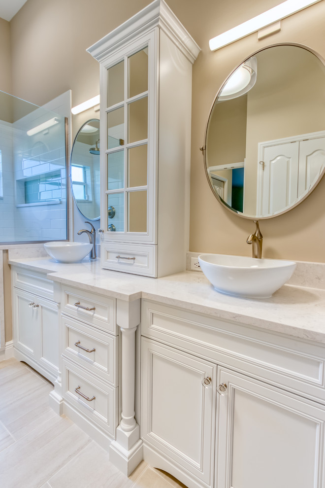 Modelo de cuarto de baño principal tradicional renovado de tamaño medio con armarios con paneles lisos, puertas de armario blancas, baldosas y/o azulejos blancos, encimera de cuarzo compacto y encimeras blancas