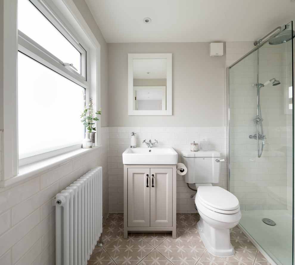 Design ideas for a medium sized classic shower room bathroom in Hertfordshire with shaker cabinets, grey cabinets, an alcove shower, a two-piece toilet, white tiles, porcelain tiles, grey walls, porcelain flooring, an integrated sink, grey floors and white worktops.