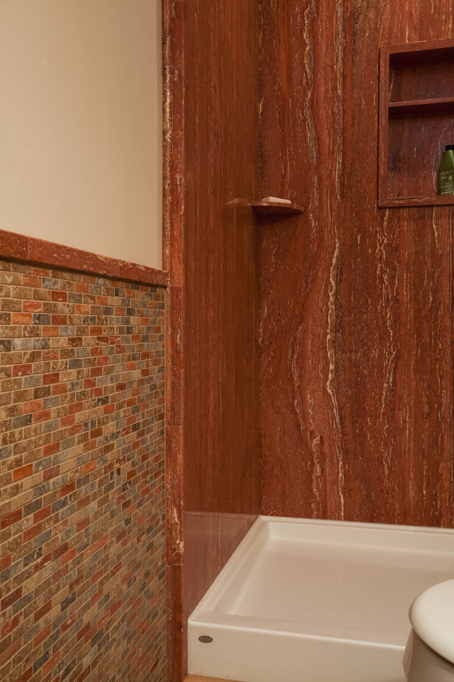 Exempel på ett rustikt badrum, med stenkakel