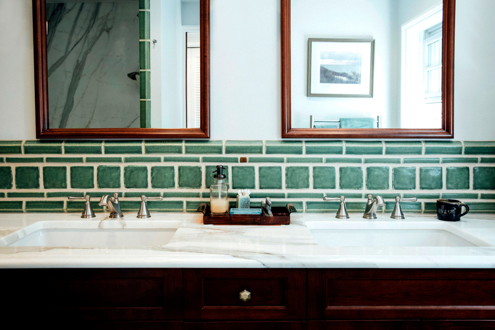 Cette image montre une salle d'eau traditionnelle en bois foncé avec une douche d'angle, un carrelage vert, des carreaux de céramique, un mur blanc, un sol en carrelage de céramique, un lavabo posé et un plan de toilette en granite.