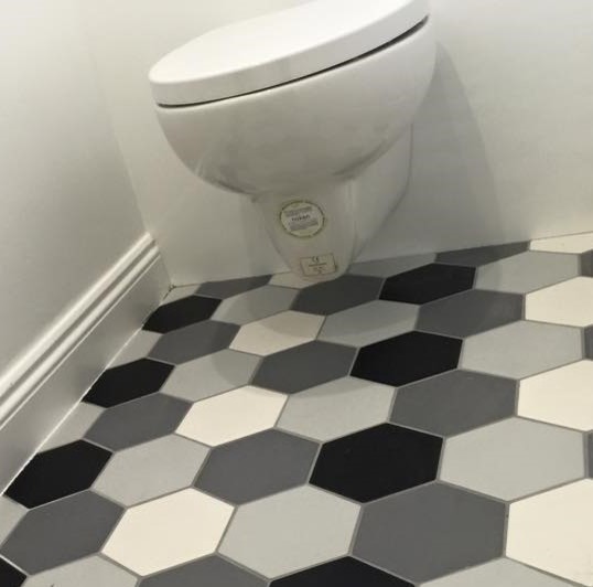 Idéer för att renovera ett funkis badrum, med en vägghängd toalettstol, porslinskakel, vita väggar och klinkergolv i porslin