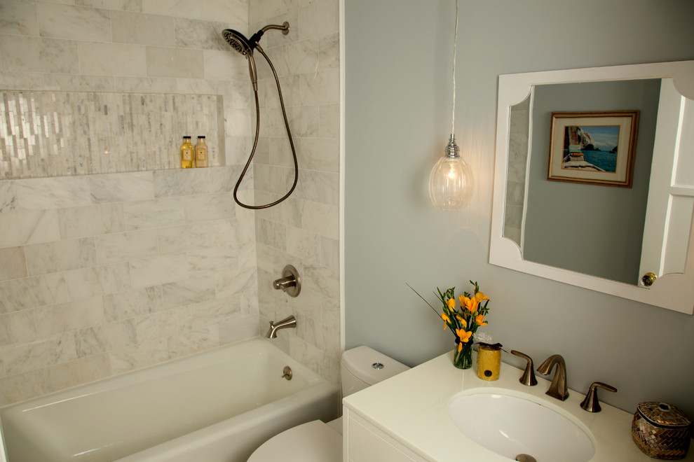 Стильный дизайн: маленькая ванная комната в стиле неоклассика (современная классика) с врезной раковиной, белыми фасадами, ванной в нише, душем в нише, унитазом-моноблоком, серой плиткой, каменной плиткой, серыми стенами и полом из керамогранита для на участке и в саду - последний тренд