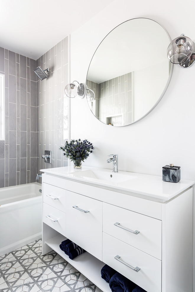 Example of a mid-sized trendy kids' gray tile and ceramic tile ceramic tile and gray floor bathroom design in Los Angeles with flat-panel cabinets, white cabinets, a one-piece toilet, white walls, an integrated sink and quartz countertops