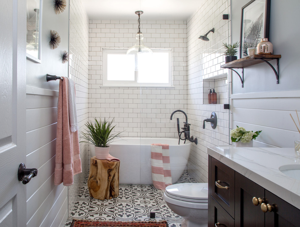 Inspiration for a medium sized rural half tiled bathroom in Los Angeles with shaker cabinets, a freestanding bath, white tiles, metro tiles, a submerged sink, brown cabinets, a built-in shower, a two-piece toilet, grey walls, cement flooring, marble worktops, black floors and an open shower.