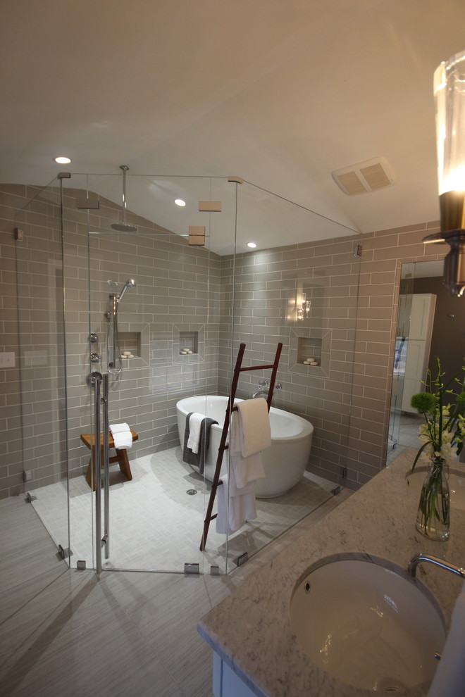Photo of an expansive modern ensuite bathroom in Raleigh with a submerged sink, shaker cabinets, white cabinets, marble worktops, a freestanding bath, a built-in shower, grey tiles, ceramic tiles, grey walls and porcelain flooring.