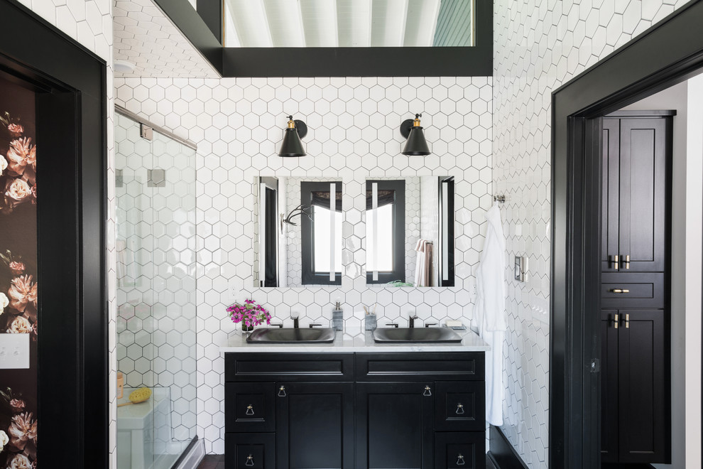 Cette photo montre une salle de bain chic avec un placard avec porte à panneau encastré, des portes de placard noires, un carrelage blanc, un mur noir, un lavabo posé et une cabine de douche à porte battante.