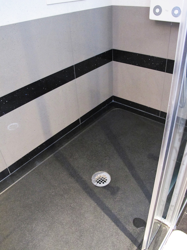 Example of a huge trendy master black tile and stone tile porcelain tile bathroom design in Montreal with an undermount sink, raised-panel cabinets, medium tone wood cabinets, quartz countertops, a one-piece toilet and gray walls