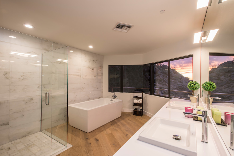 Cette image montre une salle de bain design avec une baignoire indépendante et un lavabo posé.