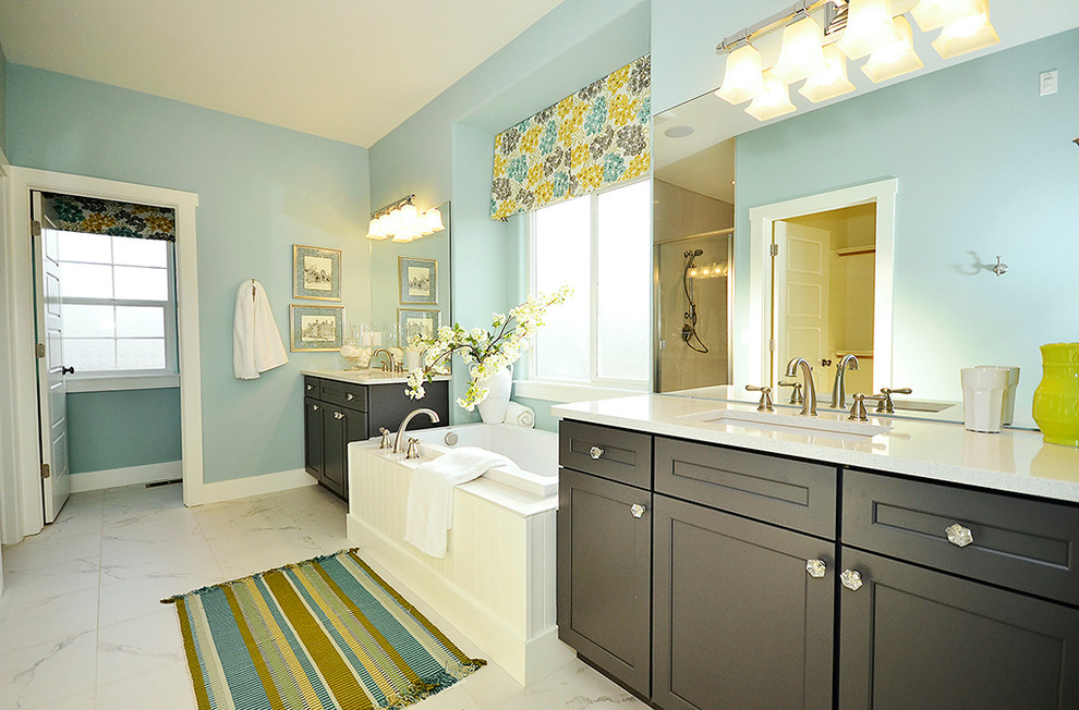 デンバーにあるトラディショナルスタイルのおしゃれな浴室 (アンダーカウンター洗面器、落し込みパネル扉のキャビネット、黒いキャビネット、ドロップイン型浴槽) の写真