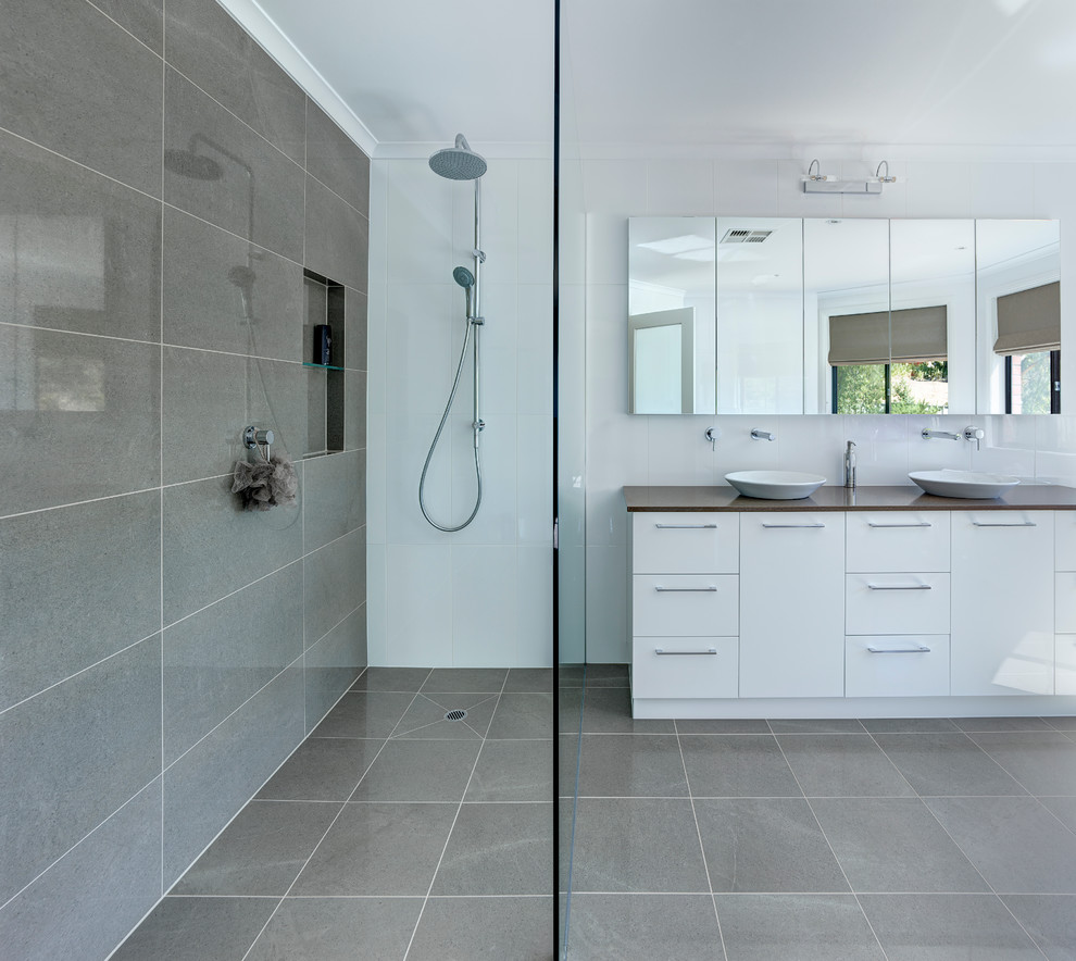 Foto di una grande stanza da bagno padronale minimal con lavabo a bacinella, vasca freestanding, doccia aperta, piastrelle grigie e pareti bianche