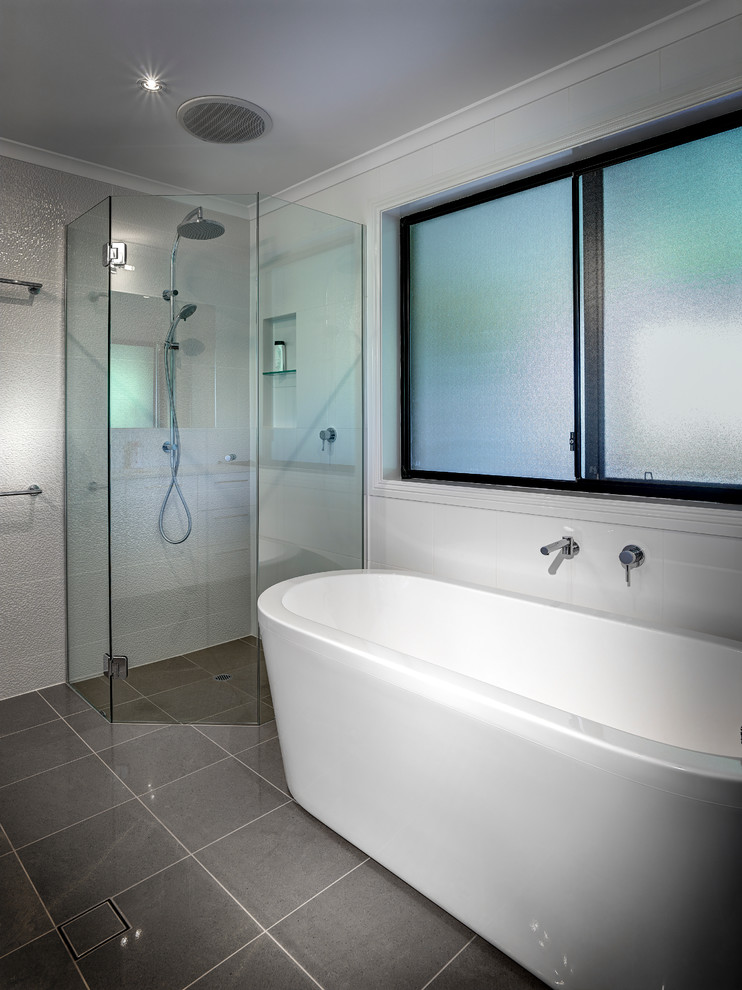 Immagine di una stanza da bagno padronale minimal di medie dimensioni con vasca freestanding, doccia alcova, piastrelle grigie e pareti bianche