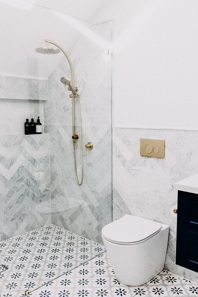 Modelo de cuarto de baño principal, único y flotante tradicional grande con armarios estilo shaker, puertas de armario azules, bañera exenta, baldosas y/o azulejos de mármol, lavabo bajoencimera y ducha abierta