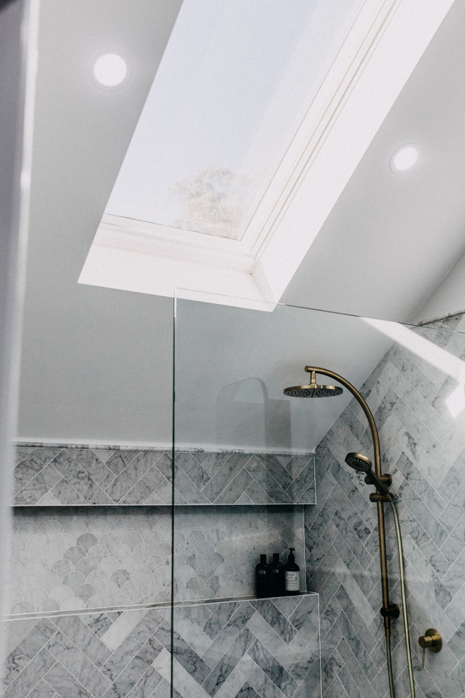 На фото: большая главная ванная комната в классическом стиле с фасадами в стиле шейкер, синими фасадами, отдельно стоящей ванной, мраморной плиткой, врезной раковиной, открытым душем, тумбой под одну раковину и подвесной тумбой с