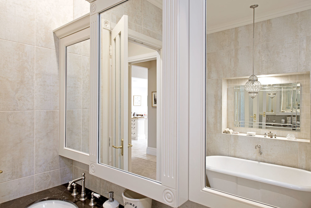 Foto de cuarto de baño principal clásico con armarios con paneles empotrados, bañera con patas, baldosas y/o azulejos de piedra, encimera de mármol y puertas de armario con efecto envejecido