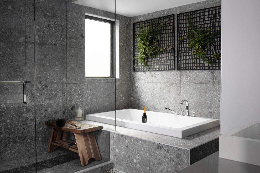 Foto de cuarto de baño actual con bañera encastrada, ducha esquinera, lavabo sobreencimera, suelo gris y encimeras grises