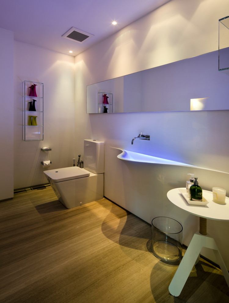 Esempio di una grande stanza da bagno con doccia minimalista con ante bianche, WC monopezzo, pareti bianche, pavimento in gres porcellanato, lavabo integrato e pavimento beige