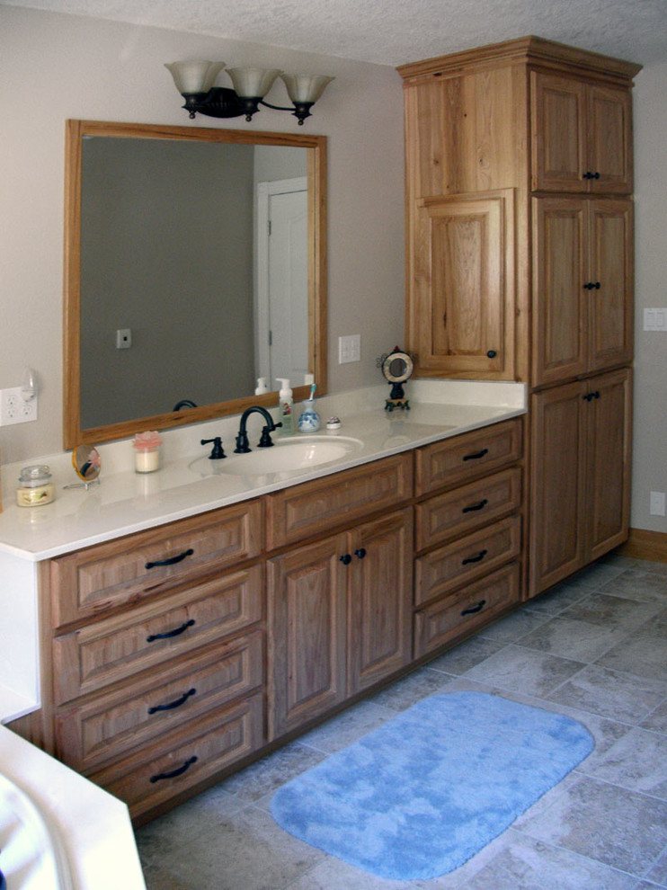 Idee per una grande stanza da bagno con ante con bugna sagomata, ante in legno scuro, pareti bianche, top bianco e vasca ad angolo