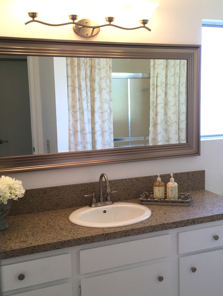 Klassisk inredning av ett mellanstort en-suite badrum, med släta luckor, vita skåp, ett badkar i en alkov, en dusch/badkar-kombination, vita väggar och ett nedsänkt handfat