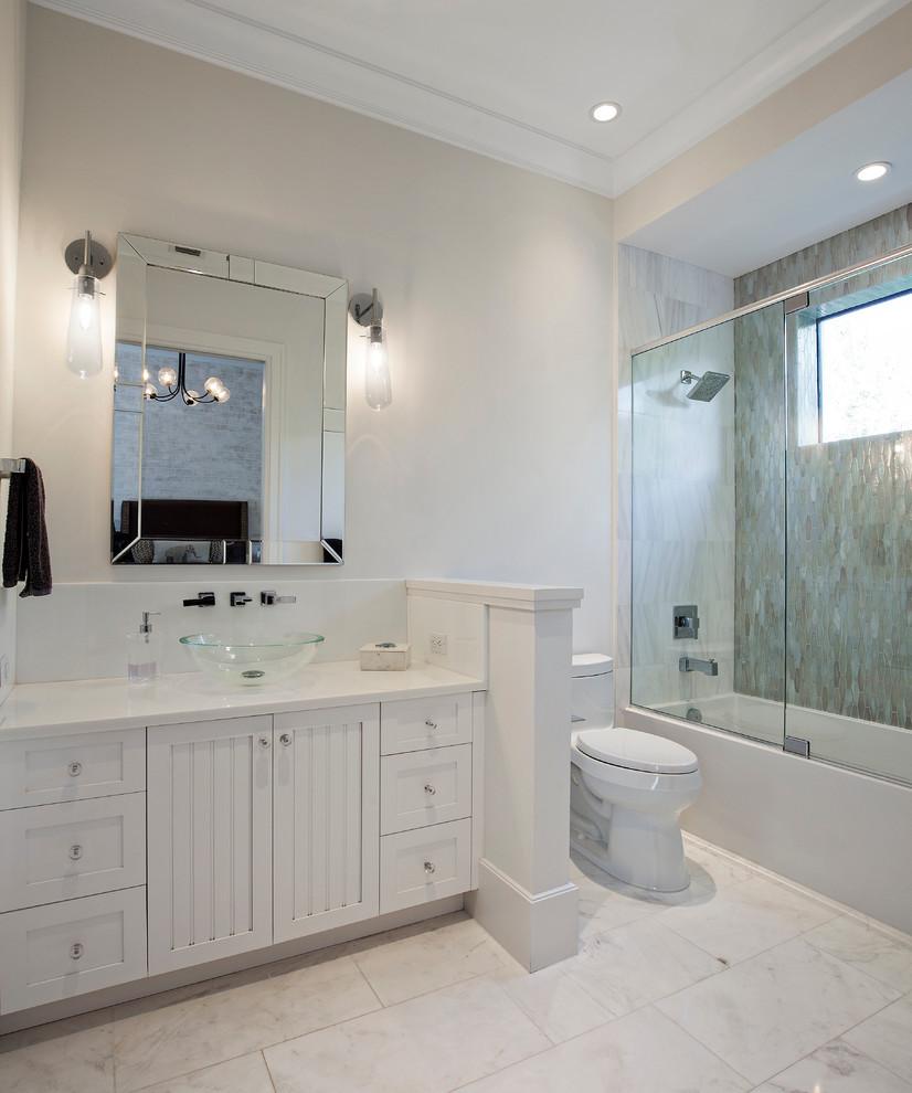 Cette image montre une grande salle de bain design pour enfant avec un placard à porte shaker, des portes de placard blanches, une baignoire en alcôve, un combiné douche/baignoire, WC à poser, un carrelage blanc, un carrelage de pierre, un mur beige, un sol en marbre, une vasque et un plan de toilette en marbre.