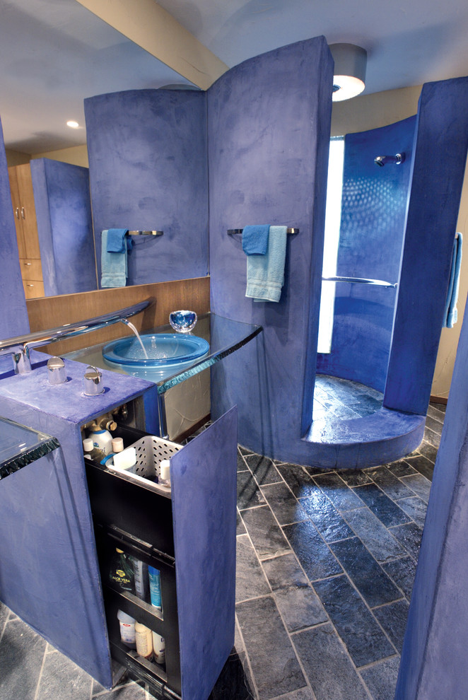 Immagine di una grande stanza da bagno con doccia minimalista con ante blu, doccia aperta, pavimento in ardesia, lavabo da incasso, top in vetro e pareti blu