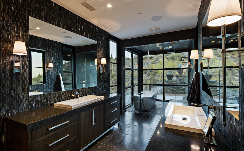 Example of a huge trendy master black tile and marble tile marble floor and black floor bathroom design in Phoenix with flat-panel cabinets, dark wood cabinets, a wall-mount toilet, black walls, a drop-in sink, marble countertops, a hinged shower door and black countertops