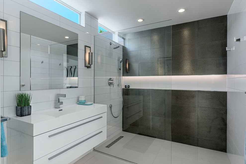 Ispirazione per una stanza da bagno moderna con lavabo integrato, ante lisce, ante bianche, doccia a filo pavimento e piastrelle bianche