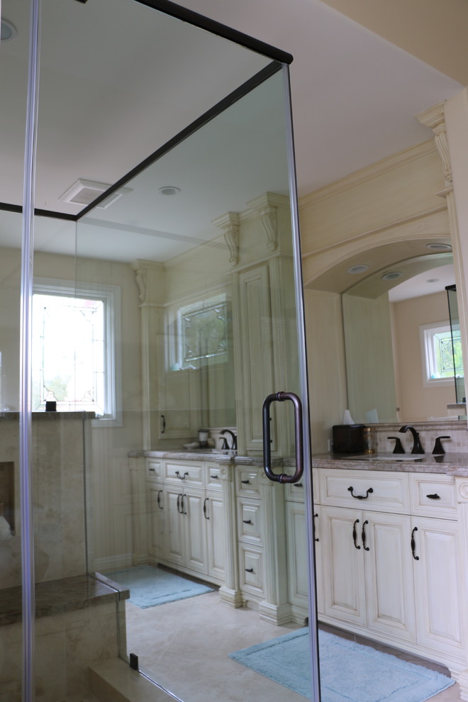 Exempel på ett stort klassiskt en-suite badrum, med ett undermonterad handfat, beige skåp, granitbänkskiva, ett platsbyggt badkar, en öppen dusch, en toalettstol med hel cisternkåpa, beige kakel, stenkakel och beige väggar