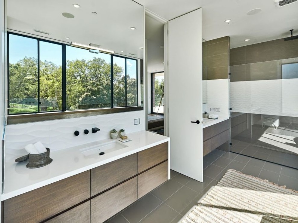 Cette image montre une grande douche en alcôve principale minimaliste en bois brun avec un placard à porte plane, un carrelage blanc, un mur blanc, un sol en carrelage de porcelaine, un lavabo encastré, un plan de toilette en quartz et un sol marron.