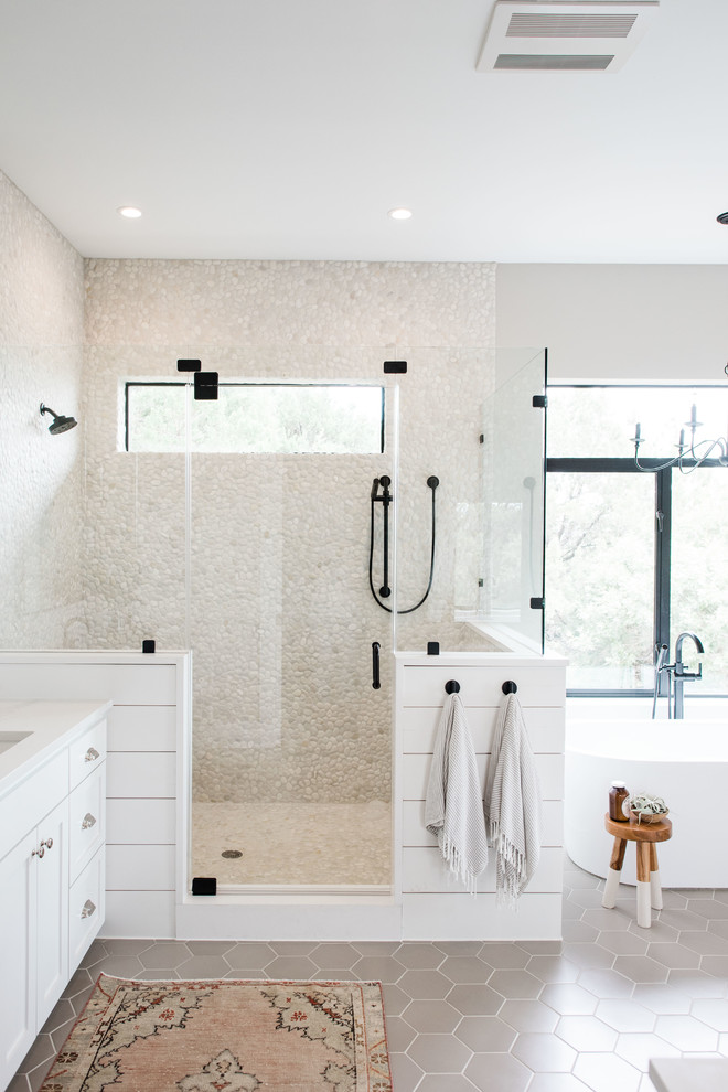 Example of a large transitional master beige tile and pebble tile porcelain tile and gray floor bathroom design in Austin with shaker cabinets, white cabinets, gray walls, an undermount sink, quartzite countertops, a hinged shower door and white countertops