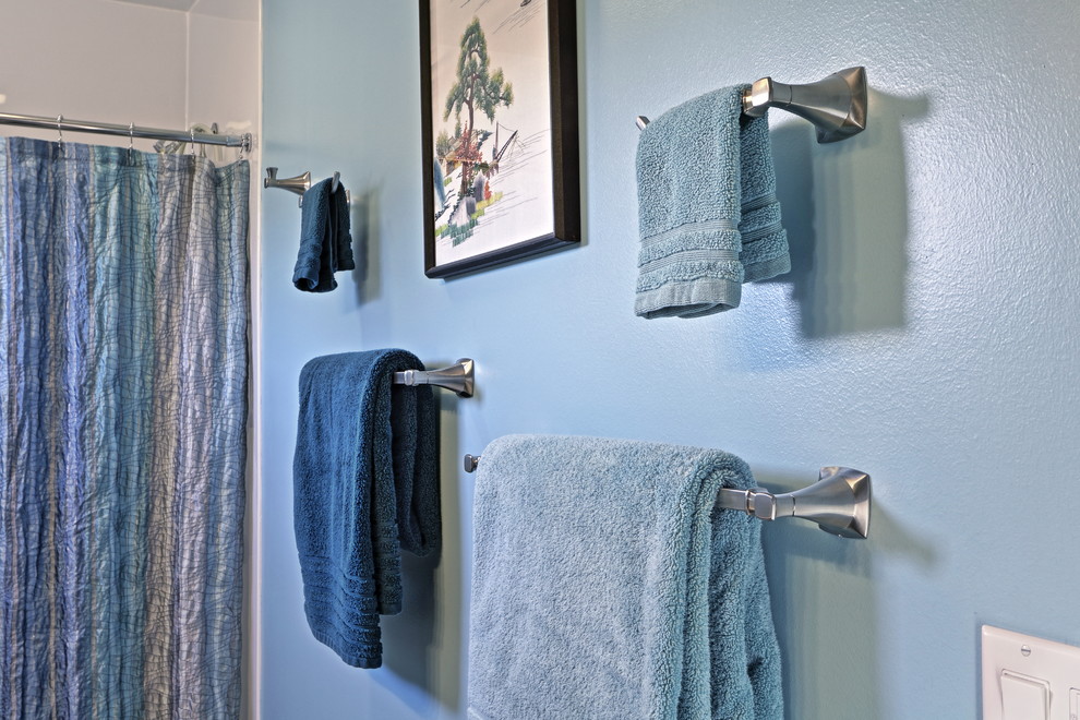 Mittelgroßes Klassisches Badezimmer En Suite mit profilierten Schrankfronten, braunen Schränken, Wandtoilette mit Spülkasten, blauer Wandfarbe, Vinylboden und Mineralwerkstoff-Waschtisch in Sonstige