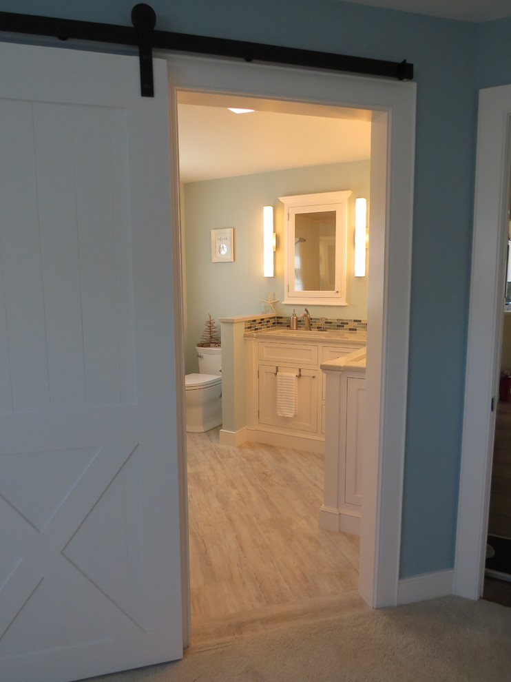 Design ideas for a medium sized nautical ensuite bathroom in Portland Maine with a submerged sink, beaded cabinets, white cabinets, engineered stone worktops, a built-in shower, a two-piece toilet, multi-coloured tiles, blue walls, porcelain flooring and glass tiles.