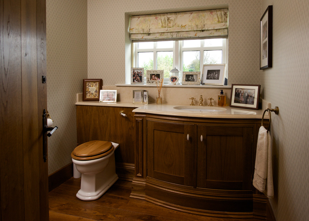 Cette photo montre une salle de bain nature en bois brun de taille moyenne avec un lavabo encastré, un placard en trompe-l'oeil, un plan de toilette en granite, WC à poser, un mur beige et un sol en bois brun.